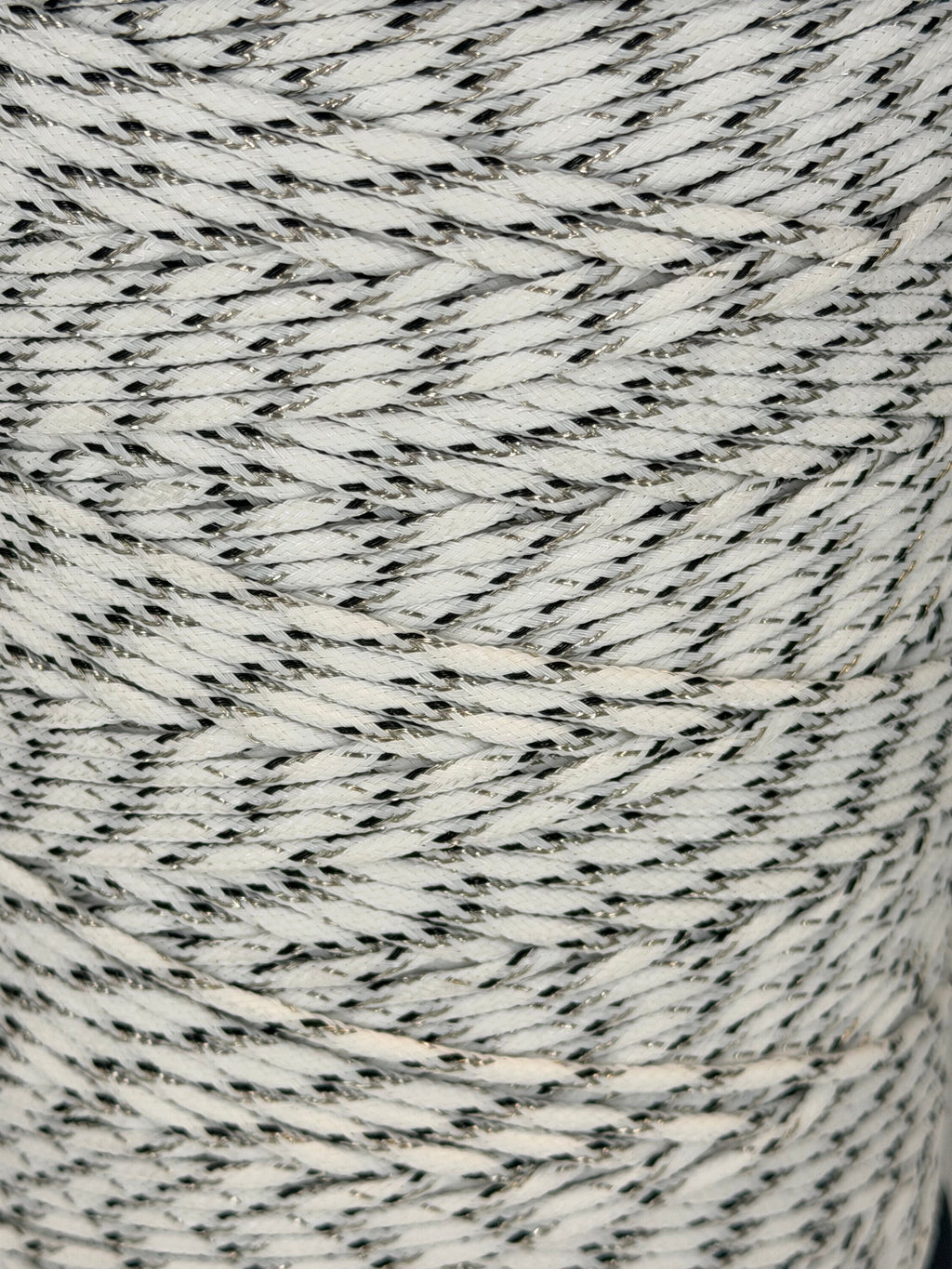 Close-up of a spool of gray and white yarn