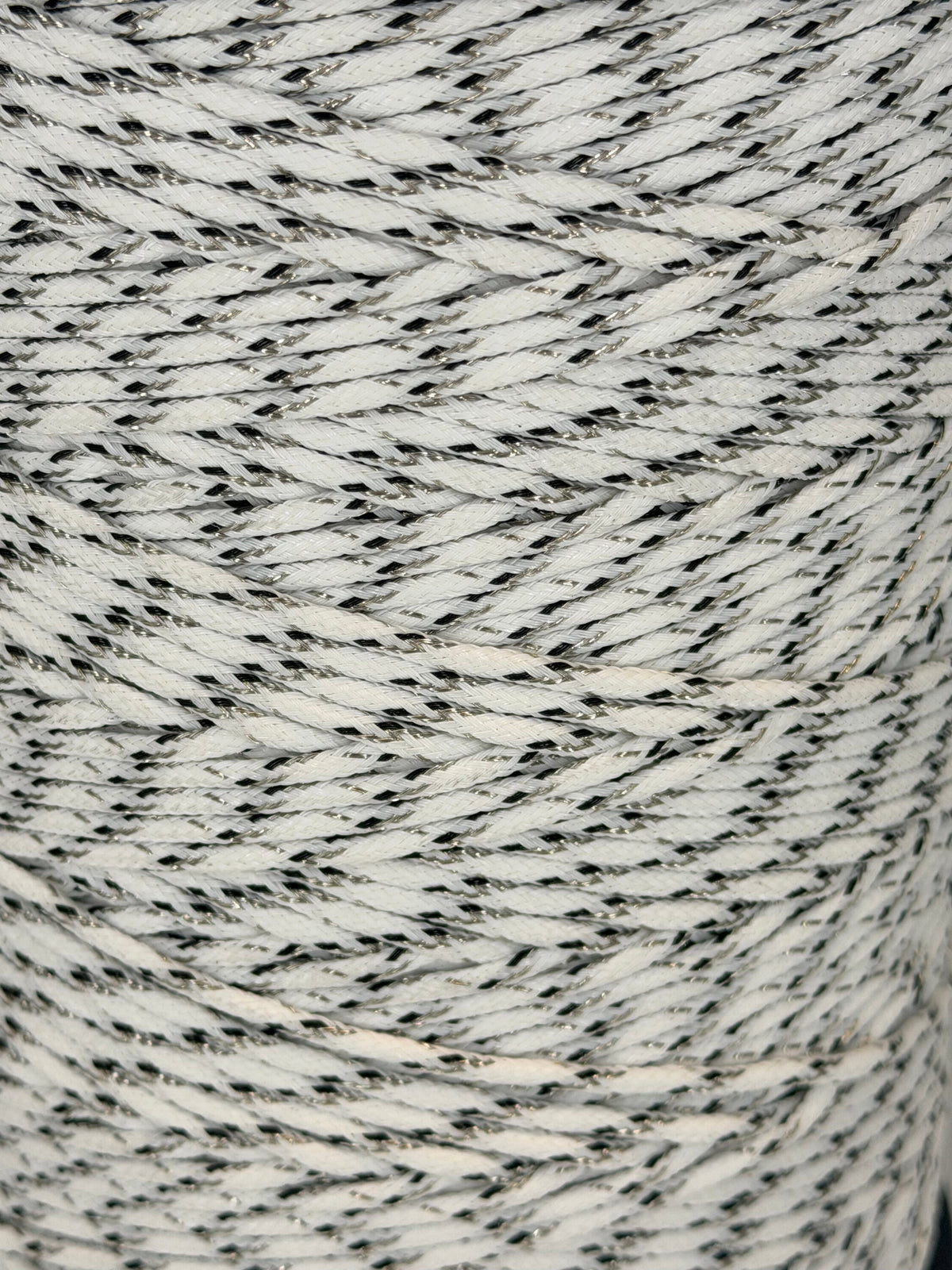 Close-up of a spool of gray and white yarn